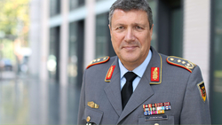Porträt eines lächelnden Bundeswehroffiziers mit grauen Haaren in Uniform mit Orden und Namensschild 'LAUBENTHAL'.