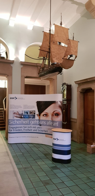 GSP-Informationsstand mit Segelschiffsmodell, der für Frieden und Sicherheit wirbt.