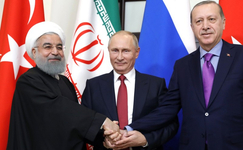 Die Präsidenten Rouhani (Iran), Putin (Russland) und Erdoğan (Türkei) schütteln sich die Hände vor ihren Flaggen.