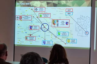 Auf eine Leinwand projizierte Karte Bayerns mit Standorten, Bezeichnungen und Reaktionszeiten militärischer Einheiten.