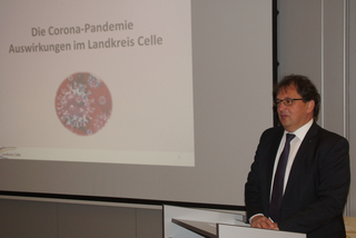 Mann im Anzug spricht vor Präsentation über Corona-Pandemie-Auswirkungen im Landkreis Celle.