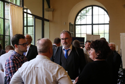 Eine Gruppe von Menschen, darunter ein bärtiger Mann in Anzug und blauer Krawatte, vernetzt sich bei einer Veranstaltung.