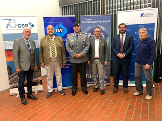 Gruppenfoto von sechs Männern, darunter ein Soldat, vor Bannern der GSP, DWT, BundeswehrVerband und Konrad Adenauer Stiftung.