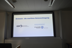 Projektionsfläche mit dem Titel „Dreizack – die maritime Netzwerktagung“ und Logos der GSP sowie Universität Rostock.