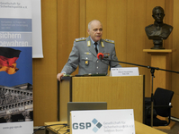 Oberst Harald Belz spricht an einem Rednerpult auf einer Veranstaltung der Gesellschaft für Sicherheitspolitik.
