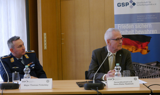 Major Thomas Finkeldey in Uniform und General Hans-Dieter Naskrent im Anzug sitzen an einem Tisch bei einer GSP-Veranstaltung.