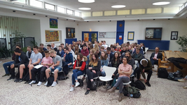 Eine große Gruppe junger Menschen, hauptsächlich Schüler, sitzt in einer hellen Halle und nimmt an einer Veranstaltung teil.