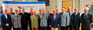 Gruppe von 15 Männern, teils in Uniform, teils in Zivil, vor "Polizeiinspektion Goslar"-Banner.