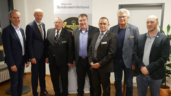 Sieben lächelnde Männer, Mitglieder des Deutschen BundeswehrVerbandes, vor dem Banner ihrer Organisation.