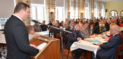 Mann an einem Rednerpult spricht vor einem Publikum, darunter Militärpersonal, bei einer GSP-Veranstaltung.