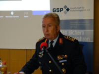 Oberst Habersetzer in Uniform spricht vor einem Mikrofon bei einer Veranstaltung der Gesellschaft für Sicherheitspolitik (GSP).