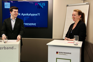 Mann und Frau lächeln bei einer Diskussion zu "Apokalypse?!" mit Logos von Polis 180 und Die Reserve.