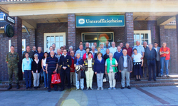 Eine Gruppe von Menschen, darunter zwei in Uniform, steht vor dem Jever Unteroffizierheim.