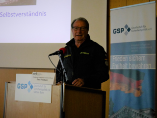 Gerd Friedsam, Präsident des THW, spricht am Podium einer GSP-Veranstaltung zum Thema Sicherheitspolitik.