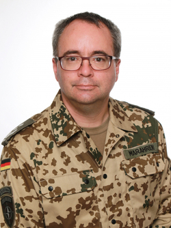 Porträt eines deutschen Soldaten (Marahren) in Wüstentarnuniform mit Brille.