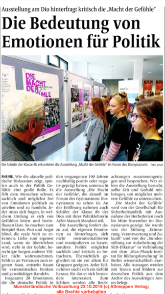 Schüler und ein Erwachsener betrachten Ausstellungstafeln zur Rolle von Emotionen in der Politik. Titel: 'Die Macht der Gefühle'.
