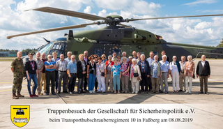 Gruppe Zivilisten und ein Soldat vor einem Transporthubschrauber bei einem Truppenbesuch in Faßberg am 08.08.2019.