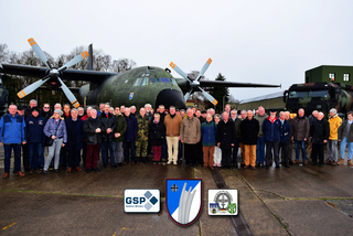 Gruppe von Veteranen oder Mitgliedern militärischer Verbände vor einem Transall C-160 Transportflugzeug und einem Militärlastwagen.