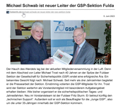 Zwei Männer, Michael Schwab und Michael Trost, lächeln und halten ein Dokument; ein GSP-Jubiläumsbanner ist im Hintergrund.
