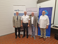 Vier Männer, darunter ein Polizist, lächeln vor Bannern der GSP, des BundeswehrVerbands und des VVT.