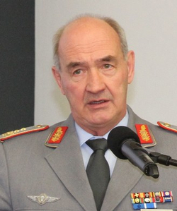 Porträt von General Eberhard Zorn in Uniform, der an einem Mikrofon spricht, mit militärischen Abzeichen und Orden.