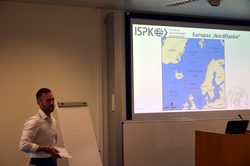 Mann präsentiert vor einer Leinwand mit einer Karte von Europas Nordflanke, Titel: ISPK Institut für Sicherheitspolitik Universität Kiel.