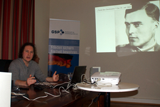 Mann hält Vortrag zum 20. Juli 1944 mit Projektion von Stauffenberg und GSP-Banner.