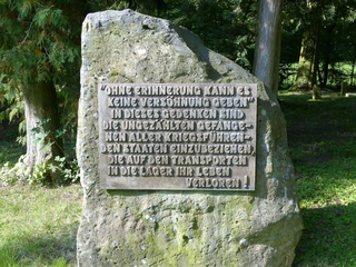 Gedenkstein mit Bronzetafel, die an Kriegsgefangene erinnert, die auf Transporten in Lager ihr Leben verloren.