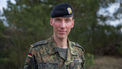 Porträt des Bundeswehrsoldaten Freuding in Flecktarn-Uniform und schwarzem Barett, lächelnd.