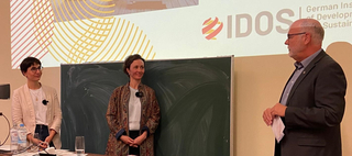 Drei Diskussionsteilnehmer, zwei Frauen und ein Mann, bei einer Konferenz des Deutschen Instituts für Entwicklung und Nachhaltigkeit (IDOS).