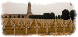 Weitläufiger Soldatenfriedhof in Verdun mit unzähligen weißen Kreuzen, dem imposanten Beinhaus von Douaumont und der französischen Flagge.