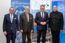 Vier Männer, darunter Harald Lem, in unterschiedlicher Kleidung (Anzüge, gemusterte Jacke, Janker) posieren bei einem Sicherheitsevent.