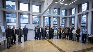 Eine vielfältige Gruppe, darunter Akademiker und Militärpersonal, posiert für ein Gruppenfoto bei einer "Winter School" in Bonn.