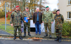 Fünf Männer, darunter vier Soldaten in deutschen Flecktarn-Uniformen und ein Zivilist, posieren im Herbst.