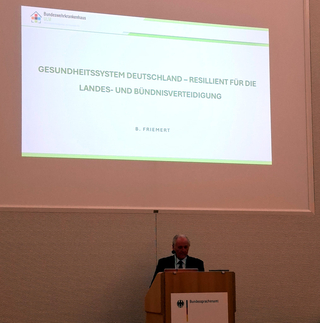 Sprecher am Bundessprachenamt-Podium, Präsentation: Gesundheitssystem Deutschland – resilient für Landes- und Bündnisverteidigung.