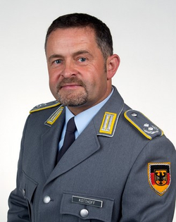 Porträt eines Mannes in deutscher Bundeswehruniform mit Dienstgradabzeichen, Bart und Namensschild KOTTHOFF.