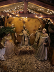 Eine beleuchtete Weihnachtskrippe mit Maria, dem Jesuskind, den Heiligen Drei Königen in einem Holzstall mit Lichterketten.