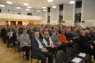 Ein großes Publikum, darunter einige in Militäruniform, sitzt in einem Konferenzsaal während einer Veranstaltung.