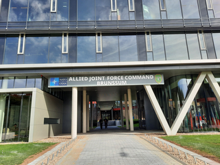 Eingang zum modernen NATO Allied Joint Force Command Brunssum Gebäude, dessen Name und Logo sichtbar sind.