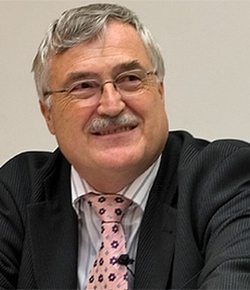 Der deutsche Politiker Klaus von Dohnanyi lächelt, trägt Brille, Schnurrbart, Anzug und gemusterte Krawatte.
