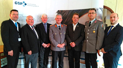 Sieben Männer, drei in Militäruniformen und vier in Anzügen, stehen vor einem Banner der GSP Gesellschaft für Sicherheitspolitik.